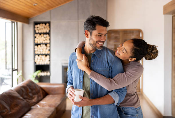 Loving couple at home hugging and looking very happy stock photo