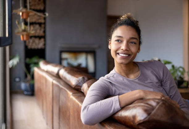 istock Thoughtful woman smiling at home while relaxing 1367252619