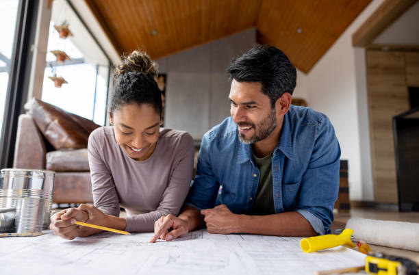 Couple remodeling their house and looking at  blueprints stock photo