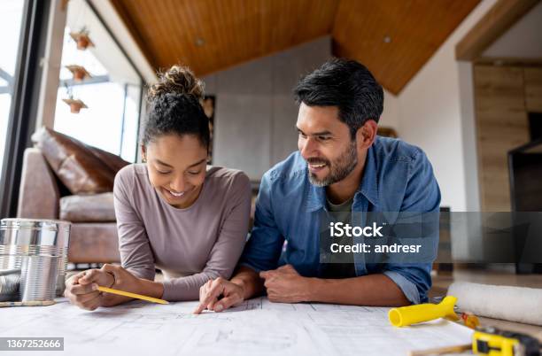 Couple Remodeling Their House And Looking At Blueprints Stock Photo - Download Image Now