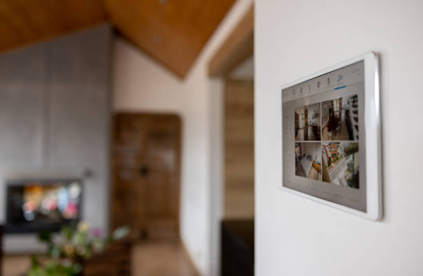 Close-up on a tablet showing the images of a security camera at a house Close-up on a tablet showing the images of a security camera at a house - modern technology concepts. **DESIGN ON SCREEN WAS MADE FROM SCRATCH BY US** indoor security camera stock pictures, royalty-free photos & images