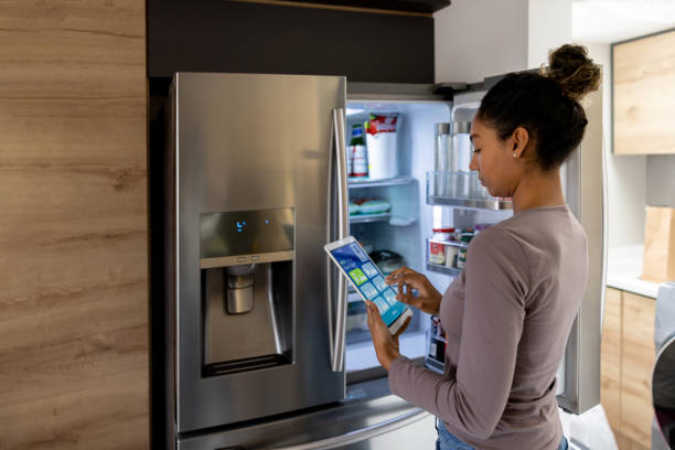 istock Woman controlling the fridge using an automated system from a tablet 1367252715