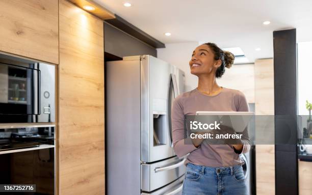 Woman Controlling The Lights Of Her Smart House Using An Automated System Stock Photo - Download Image Now
