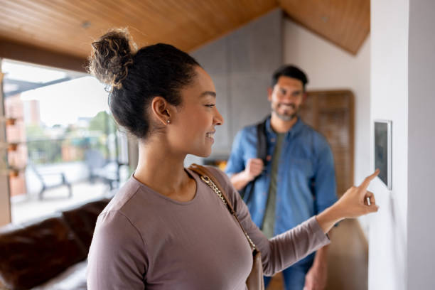 Couple leaving their house and setting the alarm using a home automated system