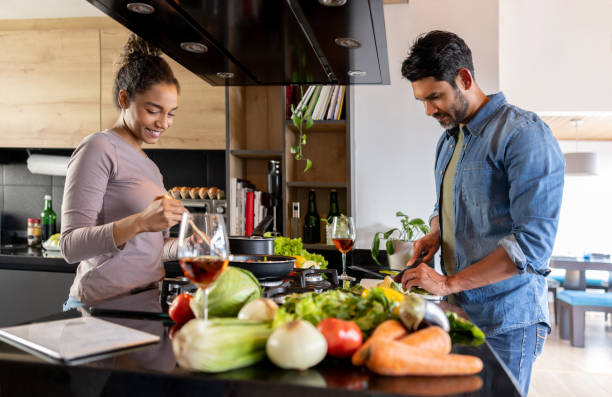istock Loving couple cooking dinner together at home 1367252785