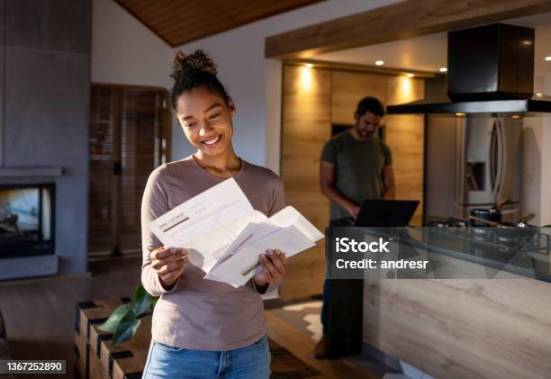 Woman At Home Looking At A Utility Bill That Came In The Mail Stock Photo - Download Image Now