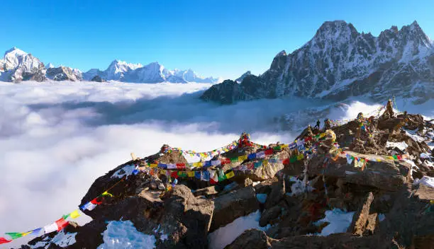view from mount Gokyo Ri peak to Arakam Tse, Cholatse, Tabuche Peak, Thamserku and Kangtega with prayer flags - trek to Everest base camp - Nepal