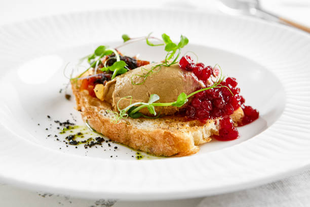 chicken liver pate on crispy bread with red currant jam and micro green. bruschetta with chicken pate in white plate. delicious appetizer - foie gras on toast. liver pate with jam in rustic style. - restaurant pasta italian culture dinner imagens e fotografias de stock