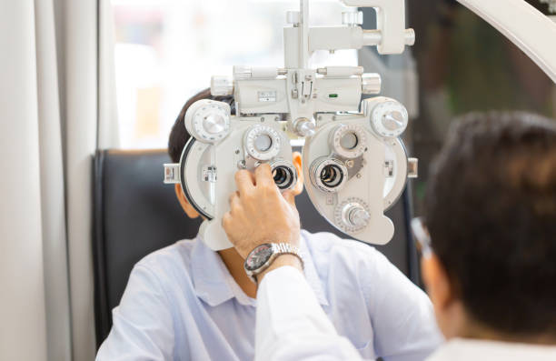 istock Optometrist doing sight testing for child patient in clinic, Boy doing eye test checking examination with optometrist in optical shop 1367257304