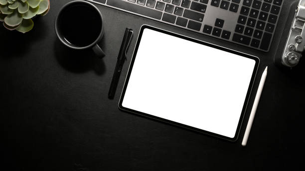 istock Modern dark office desk with electronic device gadgets and tablet mockup. 1367259751