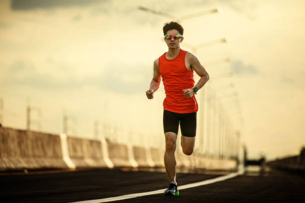 istock Young man running on colorful sunset sky 1367265847