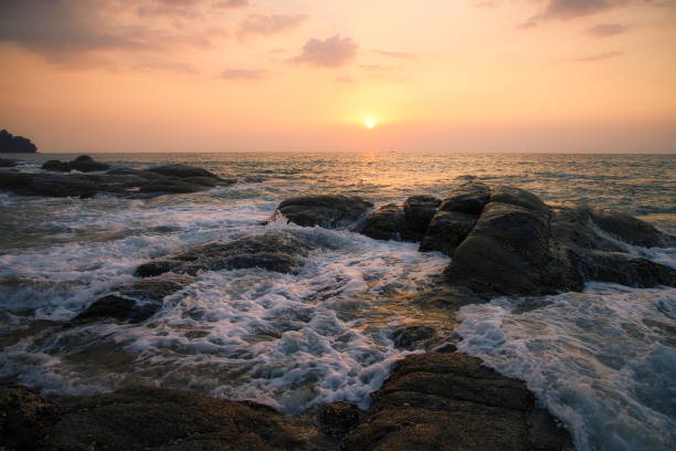 Beautiful sunset at Khao Lak beach in Thailand and you can see the wavy in the background creating a great romantic atmosphere.