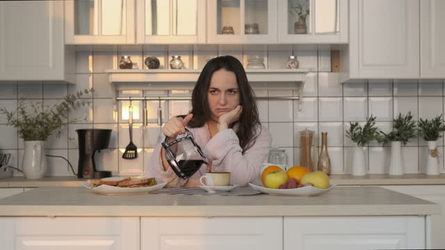 Exhausted Woman Pouring Coffee Early in Morning
