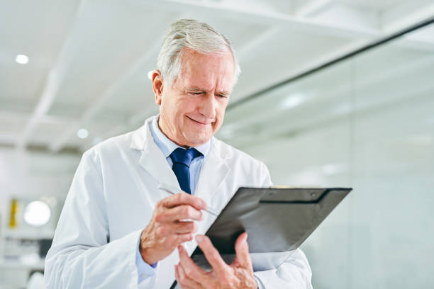 istock Shot of a senior scientist writing notes in a clipboard in a lab 1367284943