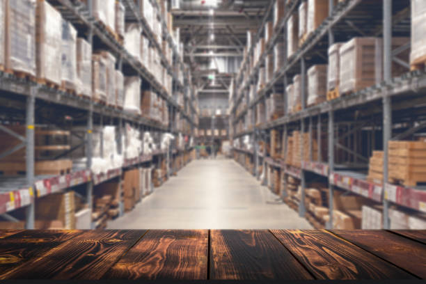 istock Warehouse with empty table background for product. Blurred industrial warehouse with goods. Logistics, business, delivery, services concept 1367286076