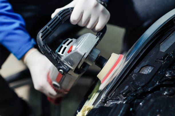 istock Car headlights cleaning with power buffer machine at car service 1367287532