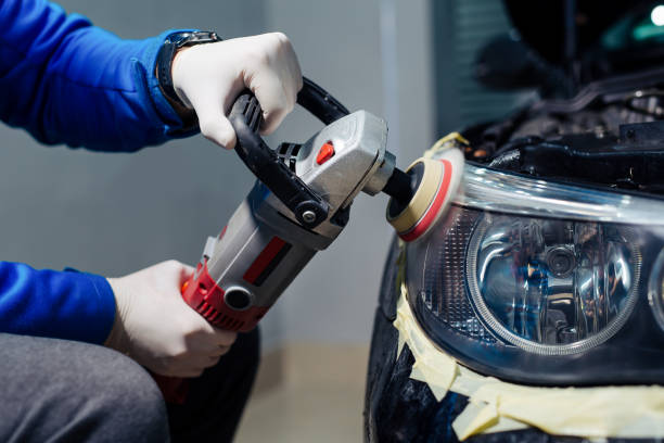 istock Car headlights cleaning with power buffer machine at car service 1367287580