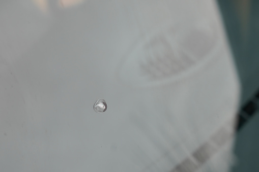 Close-up shot of rain drops on the side window of the car