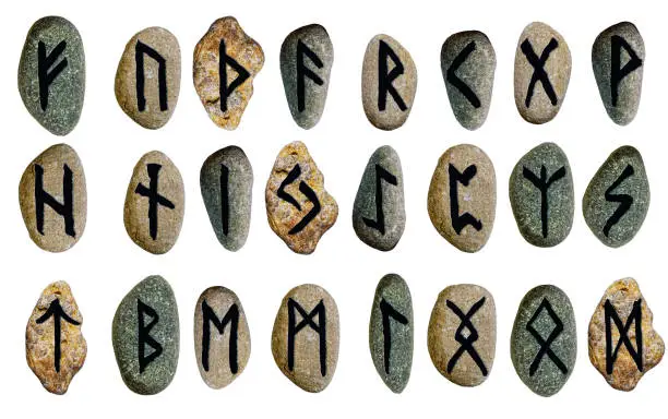 Photo of set scandinavian viking alphabet runes on stones isolated on white background