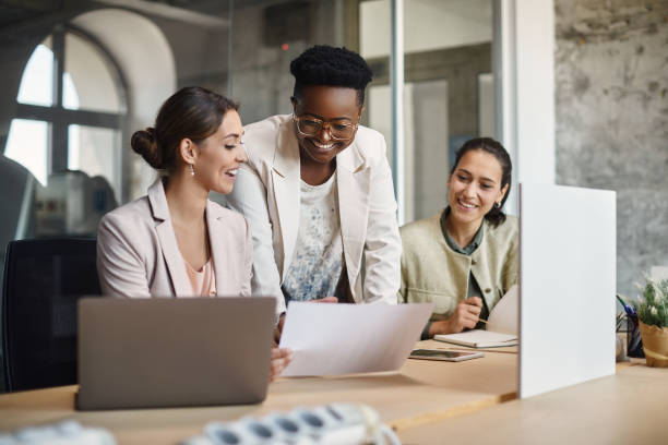 happy black ceo et ses collègues féminines analysant les rapports d’affaires au bureau. - idol photos et images de collection