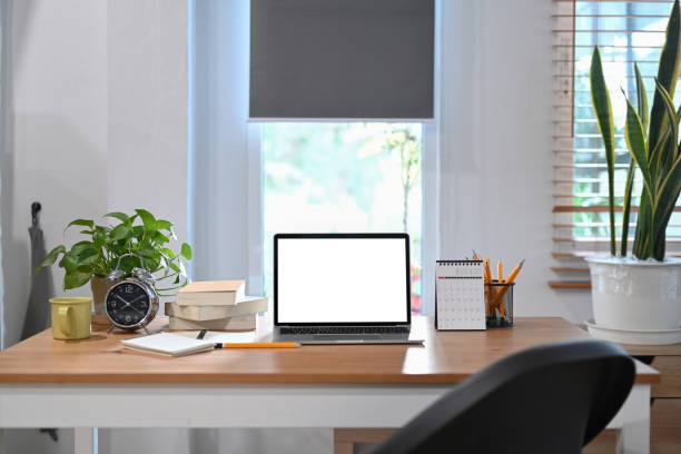 istock Computer laptop, alarm clock, potted plant and coffee cup on wooden table. 1367292582