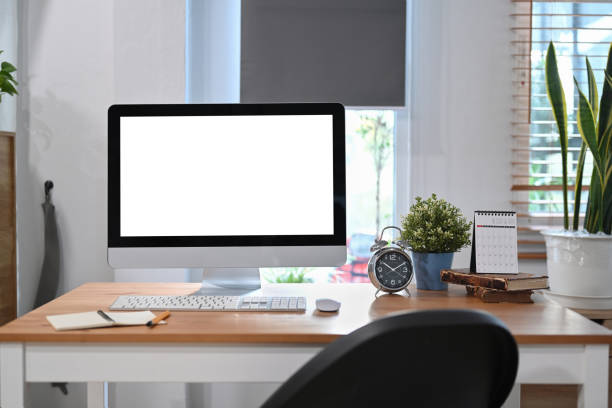 istock Home office desk with computer, alarm clock, book, coffee cup and houseplant. 1367292594