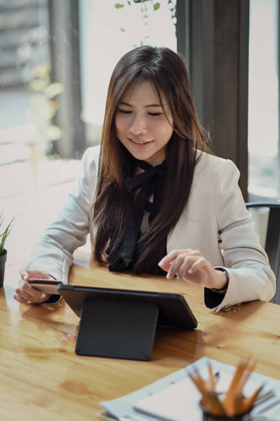 istock Attractive young businesswoman using digital tablet at office. 1367292714