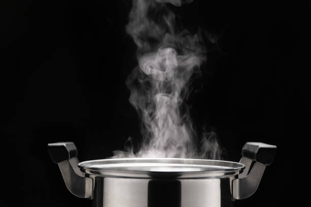 Steam over cooking pot on dark background