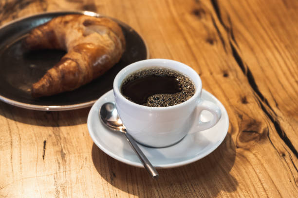 istock Black coffee with croissant. White cup of filter coffee 1367295155