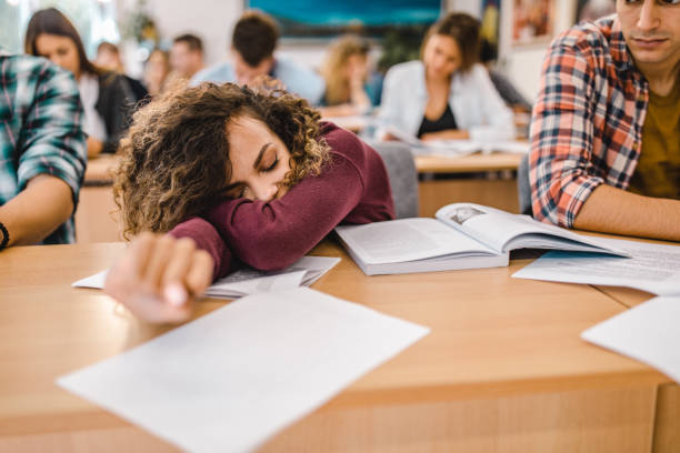 istock Tired female student sleeping on a class in the classroom. 1367296256