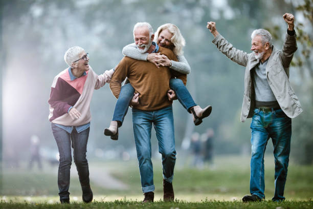istock Playful mature couples having fun during autumn day in nature. 1367297007