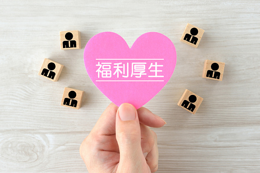 Heart objcet with welfare word in Japanese and wooden blocks with business man pictogram