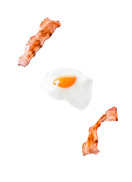 Bacon and egg as English breakfast levitate isolated on white background.