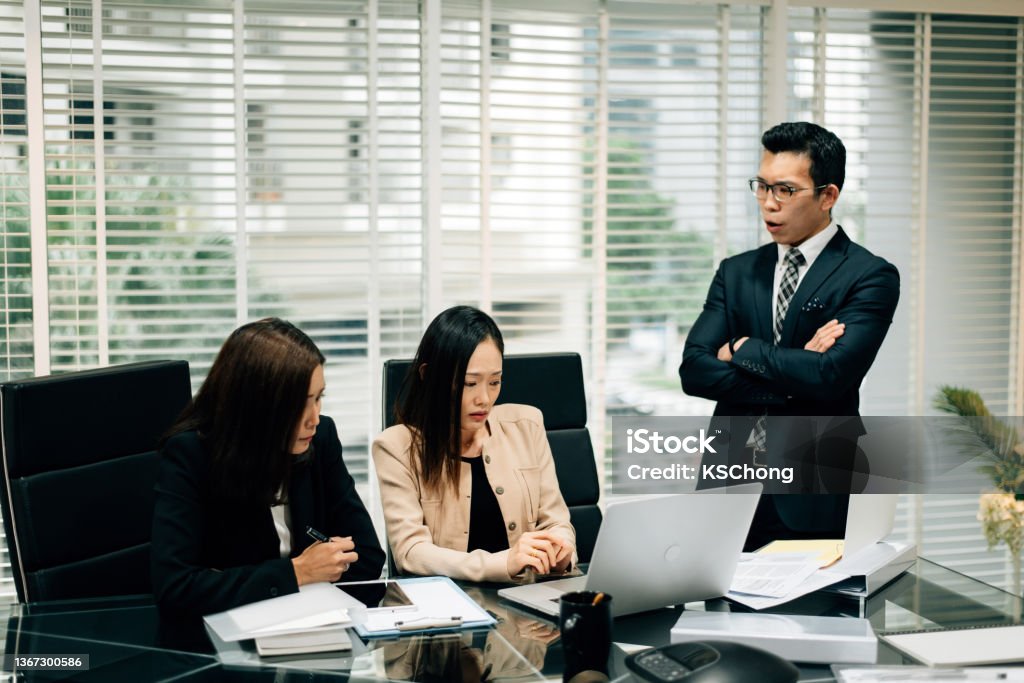 An Asian Manager is insulting his colleague in conference room An Asian Manager is insulting his colleague in conference room. Manager Stock Photo