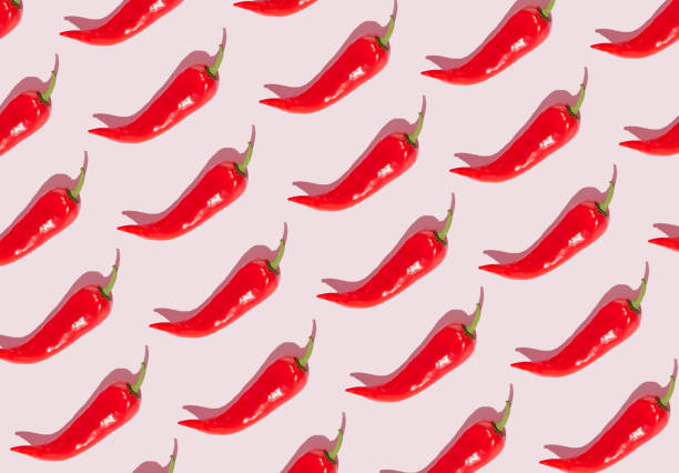 istock Pattern out of red peppers on a pink background. Minimal concept. 1367303553