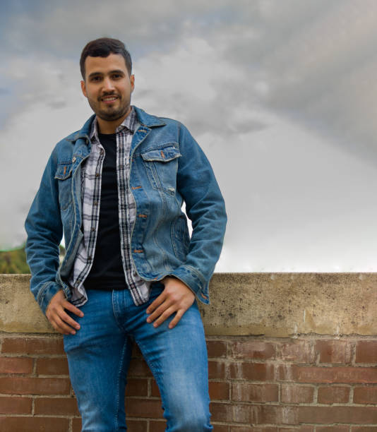 istock simple and nice latin guy leaning on a brick wall while looking at the camera 1367306024