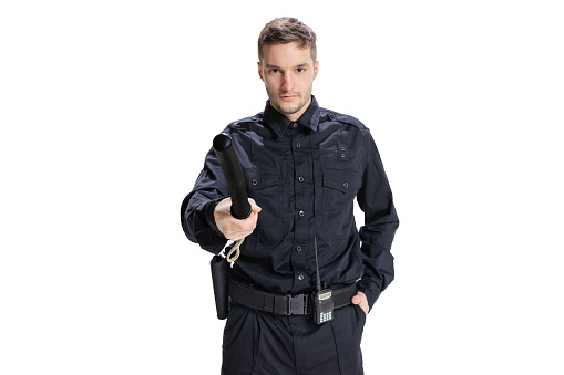 Law and order. Half-length portrait of young male policeman officer wearing black uniform posing isolated on white background. Concept of job, caree, safety. Security service. Copy space for ad