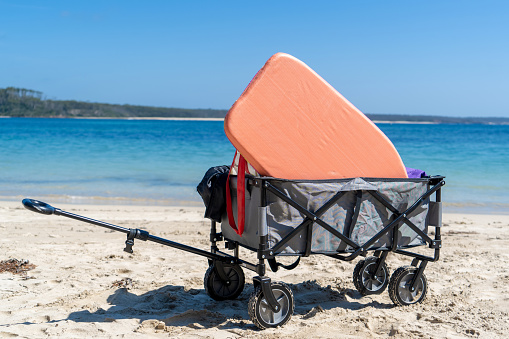 Outdoor beach cart wagon on a sandy beach near the ocean. Family vacation holidays mock up concept