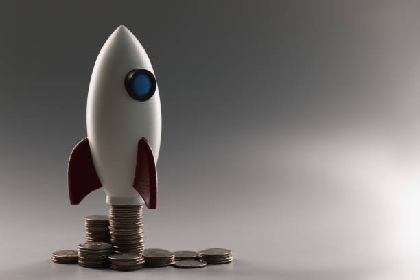 istock Plastic rocket on top of a stack of coins, close-up 1367309163