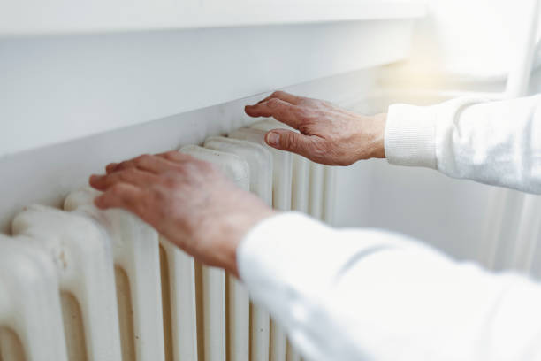 istock Men warming hands near central  heater. 1367312759