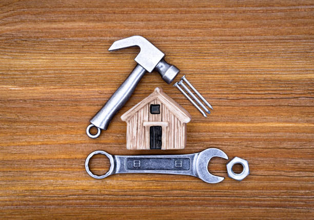 istock Toy house with hand tools and fasteners on a wooden table 1367313142