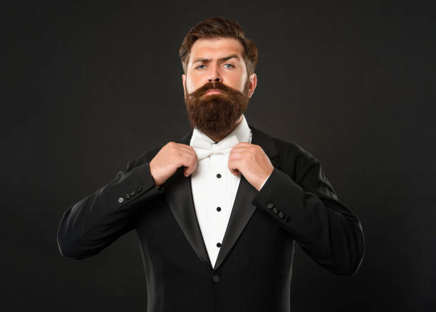 istock bearded groom in tuxedo on black background, bow tie 1367314558