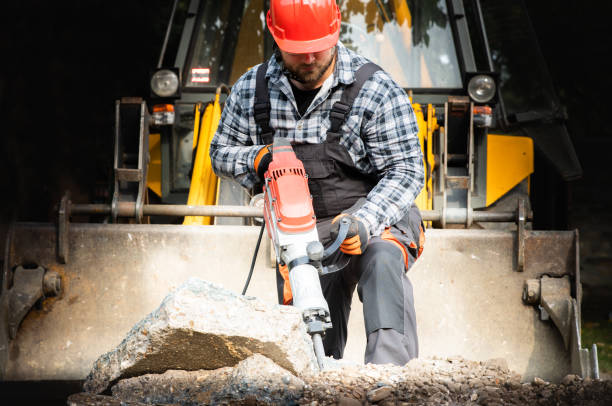 Technician in road trentch inspecting quality of works at road construction site