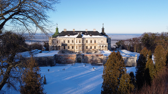 Aerial view of ancient castle at sunset in winter. Pidhirtsi Castle in the western part of Ukraine, Lviv region. Tourist place, historic building