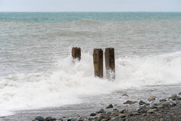 istock Old concrete pillars on the seashore during a storm. Storm waves on the shore 1367321978