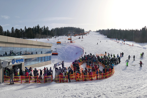 Bialka Tatrzanska, Poland - February 23, 2021: Skiers wait in line to the ski lift at the ski slope in popular winter resort Kotelnica Bialczanska during the pandemic COVID-19