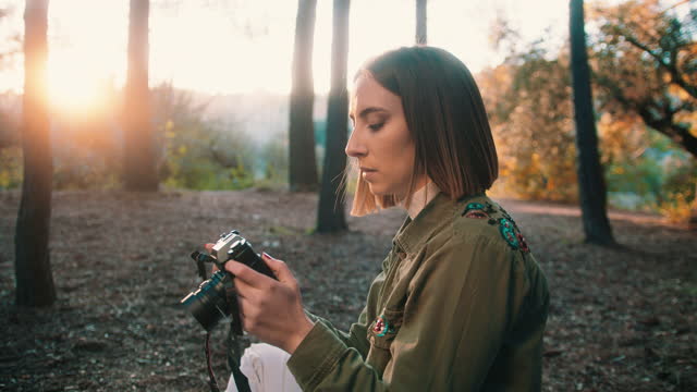 Girl loading film on vintage camera in nature at sunset. Medium shoot, Handheld