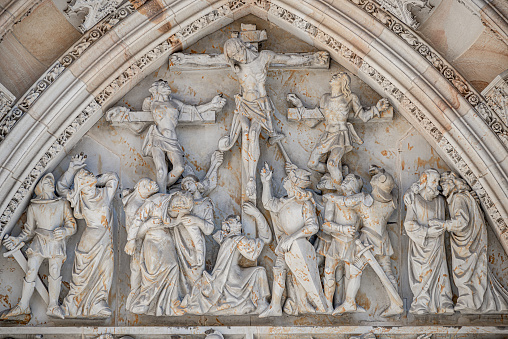 Closeup details of Crucifixion of Christ scene at major entrance portal of Saint Vitus Cathedral in Prague, Czech Republic