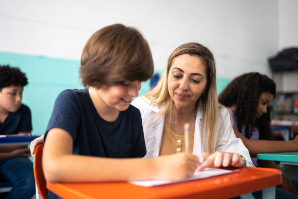 istock Teacher helping a student with a lesson in the classroom 1367328026