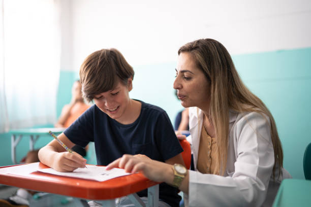 istock Teacher helping a student with a lesson in the classroom 1367328128